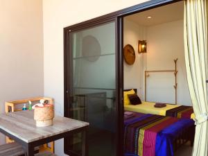 Cette petite chambre comprend une table et un lit. dans l'établissement Mae-Sa-Riang Home, à Mae Sariang