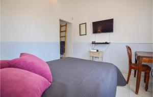 una camera da letto con un letto con cuscini viola e un tavolo di Gorgeous Home In Venzolasca With Kitchen a Venzolasca