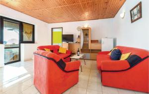 uma sala de estar com duas cadeiras vermelhas e uma televisão em Nice Apartment In Zbandaj With 2 Bedrooms And Wifi em Žbandaj