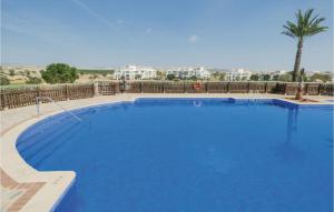 a large blue swimming pool with a palm tree in the background at 2 Bedroom Gorgeous Apartment In Sucina in Sucina
