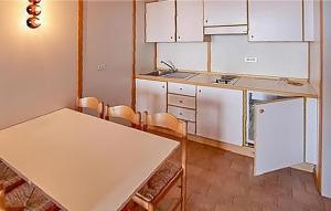 uma cozinha com armários brancos e uma mesa e cadeiras em Nice Apartment In Vason With Kitchen em Vason