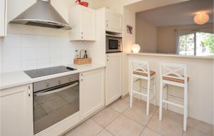 エーグ・モルトにある2 Bedroom Cozy Home In Aigues-Mortesの白いキャビネットとコンロ付きオーブンを備えたキッチン