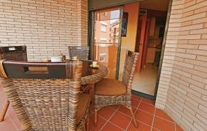 - Mesa de mimbre y sillas en el patio en Beautiful Apartment In Pineda De Mar With Kitchenette, en Pineda de Mar