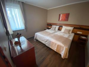 a bedroom with a large bed and a glass table at Udoben apartma v Moravskih Toplicah - Terme Vivat in Moravske Toplice