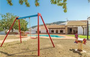a playground in front of a house with a pool at Beautiful Home In Periana With Kitchen in Periana +27 photos