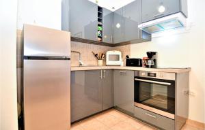 a kitchen with a stainless steel refrigerator and a microwave at 2 Bedroom Amazing Apartment In Uzes in Uzès