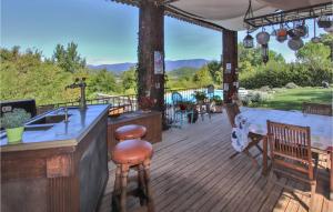 a wooden deck with a kitchen and a counter with chairs at Cozy Home In Saignon With Private Swimming Pool, Can Be Inside Or Outside in Saignon