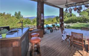 a wooden deck with a kitchen and a counter with chairs at Stunning Home In Saignon in Saignon