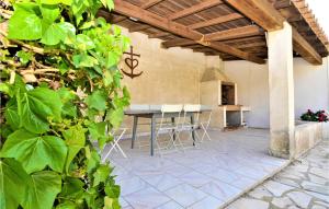 eine Terrasse mit einem Tisch und Stühlen in einem Gebäude in der Unterkunft Awesome Home In Bellegarde With Kitchen in Bellegarde