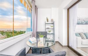 ミハス・コスタにある2 Bedroom Lovely Apartment In Mijas Costaのガラスのテーブルと椅子、窓が備わる客室です。