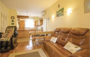 a living room with a brown leather couch at Stunning Apartment In Lovran With 2 Bedrooms, Wifi And Outdoor Swimming Pool in Lovran