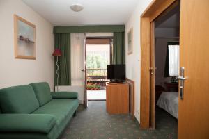 uma sala de estar com um sofá verde e uma televisão em Hotel Secesja em Cracóvia