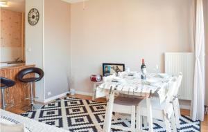 格朗德康邁西的住宿－1 Bedroom Nice Apartment In Grandcamp Maisy，一间配备有白色桌椅的用餐室