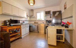 eine große Küche mit weißen Schränken und einer Arbeitsplatte in der Unterkunft 3 Bedroom Gorgeous Home In Cervione in Prunete