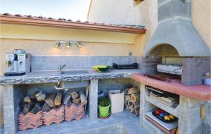 eine Küche mit Steinofen und Spüle in der Unterkunft 3 Bedroom Gorgeous Home In Cervione in Prunete