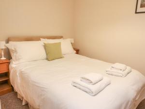 a bedroom with a bed with white towels on it at MacGregor in Pitlochry