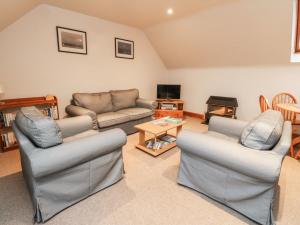 a living room with two couches and a tv at MacGregor in Pitlochry