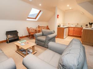 uma sala de estar com um sofá e uma mesa em MacGregor em Pitlochry