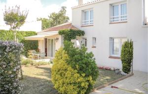 a white house with bushes in front of it at Beautiful Home In La Faute Sur Mer in La Faute-sur-Mer