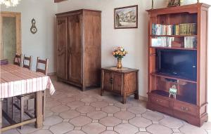 una sala de estar con TV y un jarrón de flores en Amazing Home In La Faute Sur Mer With Kitchen, en La Faute-sur-Mer