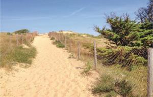 a dirt road with a fence on the side at Beautiful Home In La Faute Sur Mer in La Faute-sur-Mer