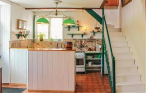 a kitchen with a staircase leading up to a kitchen counter at Holiday Home Rue De Kroas Prenn in La Forêt-Fouesnant