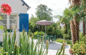 a patio with a table and chairs and an umbrella at Holiday Home Rue De Kroas Prenn in La Forêt-Fouesnant +11 photos