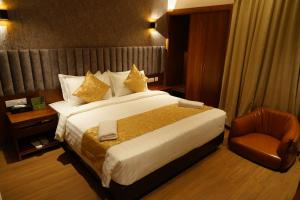 una habitación de hotel con una cama grande y una silla en The Kings Park Grand-Near US Consulate en Chennai