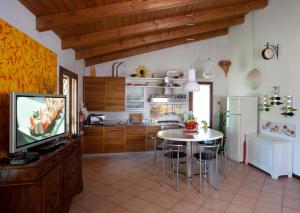 a kitchen with a table and a tv in a room at Elena Paternoster in San Lazzaro di Savena