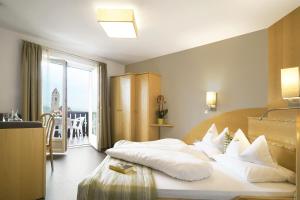 - une chambre avec un lit doté d'oreillers blancs dans l'établissement Hotel Sonnenhof, à Marlengo