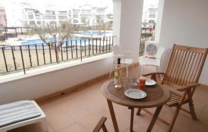 a room with a table and chairs and a balcony with a pool at Amazing Apartment In Roldn With 2 Bedrooms, Wifi And Outdoor Swimming Pool in Los Tomases