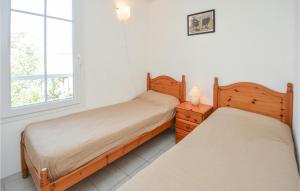 a bedroom with two beds and a window at 3 Bedroom Awesome Home In Aigues-Mortes in Aigues-Mortes +25 photos