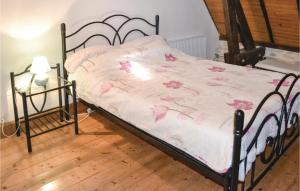 a bed with a white comforter with pink flowers on it at Stunning Home In La-Chapelle-Saint-Jean in La Chapelle-Saint-Jean