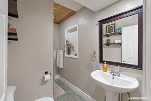 a white bathroom with a sink and a mirror at Portage Place Family Retreat in Wasilla