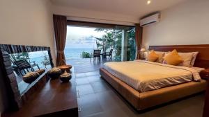 a bedroom with a bed and a view of the ocean at The Hideaway in Thong Nai Pan Noi