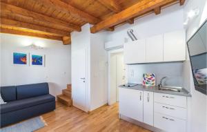 a kitchen with white cabinets and a blue couch at Awesome Home In Pag With Wifi in Pag +17 photos