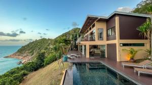 a house with a swimming pool next to the ocean at The Hideaway in Thong Nai Pan Noi