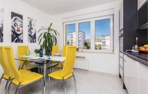 a kitchen with a glass table and yellow chairs at Stunning Apartment In Rijeka With 1 Bedrooms And Wifi in Rijeka