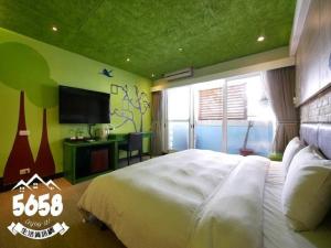 - une chambre avec un grand lit blanc et une télévision dans l'établissement R8 Eco Hotel, à Kaohsiung