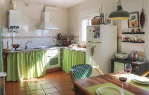 een keuken met groene gordijnen, een tafel en een koelkast bij Nice Home In Canillas De Albaida With Wifi in Canillas de Albaida