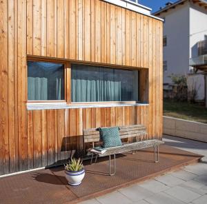 ズルデルノにあるHaus18の木造建築の前に座るベンチ