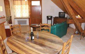 a room with a wooden table with a bottle of wine at Gîte Du Jocou in Glandage