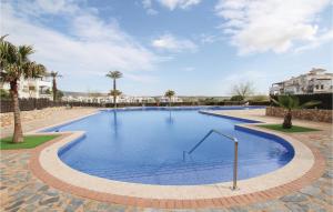 uma grande piscina com água azul e palmeiras em Awesome Apartment In Sucina With Wifi em Sucina