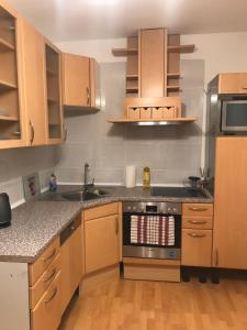 a kitchen with wooden cabinets and a stove top oven at Apartmany Lend in Lend