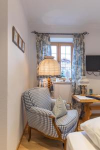 a living room with a chair and a desk at Hotel garni Reiffenstuel in Rottach-Egern