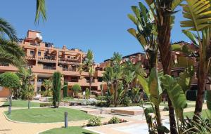 a large building with palm trees in front of it at Beautiful Apartment In Estepona With 2 Bedrooms, Wifi And Outdoor Swimming Pool in Estepona