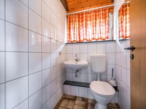 a bathroom with a toilet and a sink at Rustic holiday home in the Hochsauerland with balcony at the edge of the forest in Schmallenberg