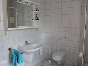 a white bathroom with a sink and a toilet at House with interior and garden in Volcanic Eifel in Strotzbüsch