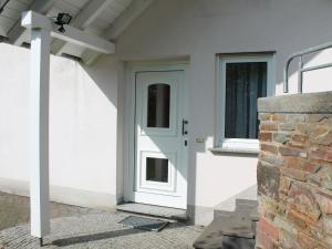 a white door on a house with a brick wall at House with interior and garden in Volcanic Eifel in Strotzbüsch