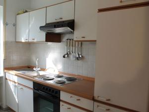 a kitchen with white cabinets and a stove top oven at House with modern interior and garden in the Volcanic Eifel near deer game park in Strotzbüsch